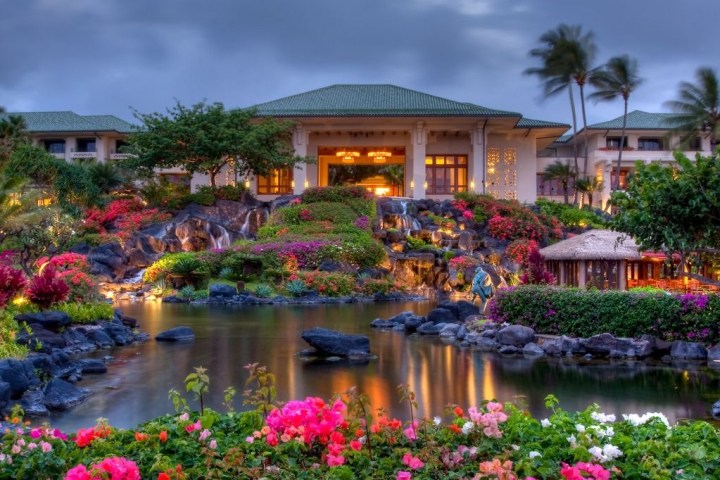 a house with bushes in front of a body of water